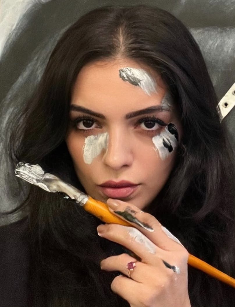 Seda Yeğen, elinde boya fırçası ve yüzünde boya izleriyle